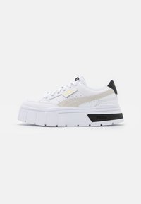 Sneaker platform bianche con tomaia in pelle liscia, dettagli di design perforati e accenti beige e neri. Presentano lacci piatti e una suola spessa.