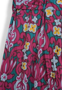 Colorful dress featuring a floral pattern in shades of pink, yellow, and blue with swirling designs and a silky texture.