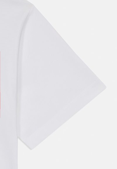 Camiseta de algodón blanca con manga corta, que presenta una textura suave y un diseño impreso en la parte delantera. Los dobladillos y costuras de los puños están ligeramente enrollados.
