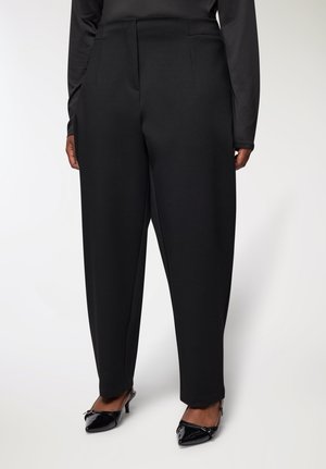 Pantaloni neri su misura con vita alta, gamba larga e pinces. Il materiale appare liscio con una leggera lucentezza.