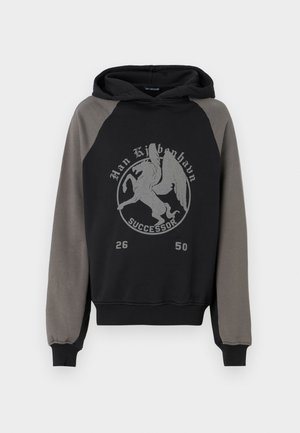 Hooded sweatshirt with a black body and gray raglan sleeves. Features a centered graphic print of a winged creature, text, and numbers.