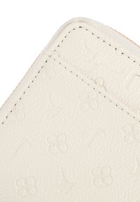 Weißes Lederportemonnaie mit geprägten Blumen- und Buchstabenmustern, mit kontrastierendem Stich an den Rändern. Glatte Textur und kompaktes Design.