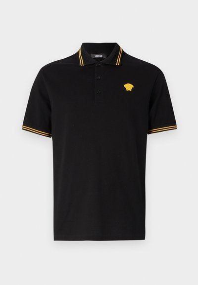 Črna polo srajca iz bombaža, ki ima ovratnik in manšete v rumenih črtah, ter rumeno izšito logo na prsih. Zapenjanje z trimi gumbi.