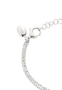 Pulsera de cadena de plata con un cierre de langosta, que presenta múltiples cadenas enlazadas y una etiqueta ovalada grabada. Superficie de metal suave y acabado pulido.