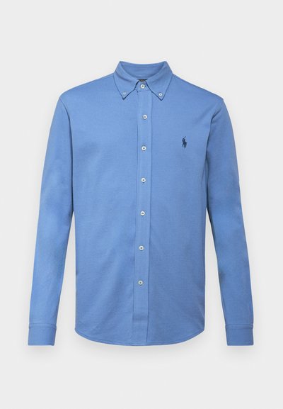 Long-sleeve, light blue button-down shirt in cotton blend. Features a classic collar, button front, and small embroidered logo in navy.
