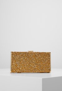 Prostokątna kopertówka z wykończeniem ze złotego brokatu, metalicznymi krawędziami i zapięciem na zatrzask. Gładka faktura z połyskującymi elementami.