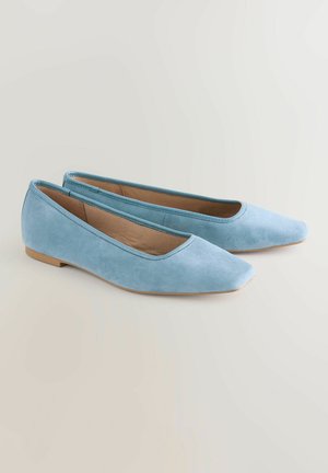 Gai zila zamšādas kurpes ar norādītu purngali, minimālistisks dizains, viegli papēdis un gluda virsma. Plakanā zole un iekšpuse bēšā krāsā.