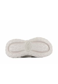 Semelle de sneaker blanche avec un motif de grip texturé, présentant des formes hexagonales et en diamant. Matériau en caoutchouc solide offrant une bonne adhérence.