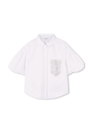 Blouse blanche à manches courtes avec un col, dotée d'une poche à rabat texturée sur le côté gauche. Fabriquée en tissu lisse avec un léger éclat.