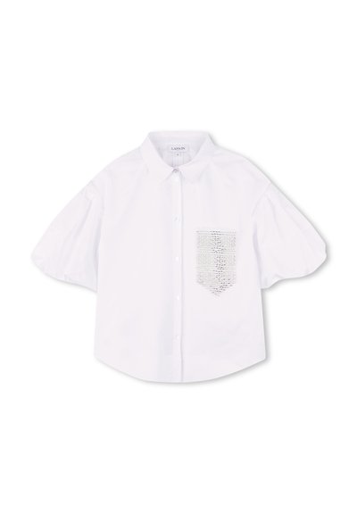 Blouse blanche à manches courtes avec un col, dotée d'une poche à rabat texturée sur le côté gauche. Fabriquée en tissu lisse avec un léger éclat.