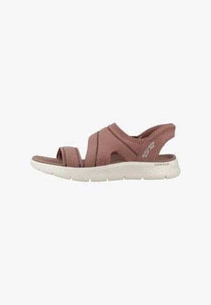 Sandalias tejidas de color rosa claro con un acabado texturizado, que presentan tiras entrecruzadas y una suela blanca acolchada para mayor comodidad.