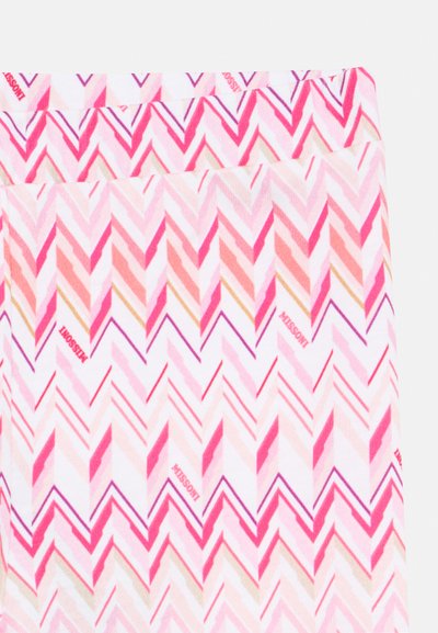 Tissu à motif zigzag coloré dans des tons de rose, rouge et crème. Le matériau semble doux avec une texture lisse. Logo visible sur la ceinture.