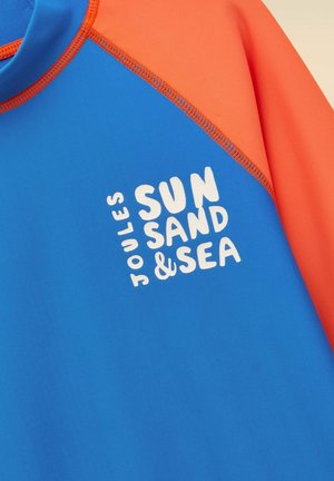 Blaues und oranges Langarmshirt mit weißem Text "Joules Sun Sand & Sea" auf der Vorderseite gedruckt.
