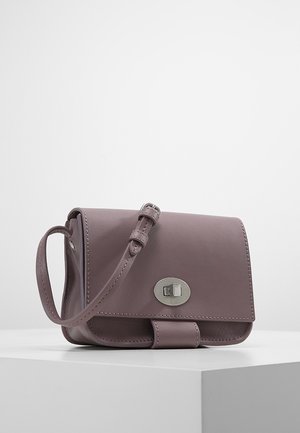 Piccola borsa tracolla in pelle color malva con tracolla regolabile e chiusura a torsione argentata su superficie bianca.