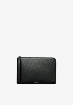 Schwarze Lederbörse mit strukturiertem Oberflächen, rechteckiger Form, Reißverschluss und einem kleinen Logo-Detail auf der Vorderseite.