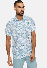 Camisa de botón de manga corta en azul claro con un estampado de bambú y montañas. Presenta un cuello y botones de madera clara.