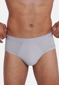 Grå bomullsboxer med en mjuk elastisk midja. Har en framficka och tonad sömnad. Logotypen "SLOGGI" är synlig på midjan.