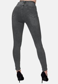 Szare obcisłe jeansy z wysokim stanem, z pięciokieszeniowym designem i gładkim, elastycznym materiałem. Połączone z czarnymi szpilkami.