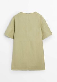 Tunique en lin vert olive à coupe droite, manches courtes, encolure en V, avec des détails de coutures visibles à l'arrière.