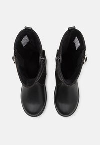 Bottines noires avec un extérieur en cuir lisse, un bout arrondi et une doublure douce. Des zips latéraux et des accents de boucle décoratifs sont visibles.