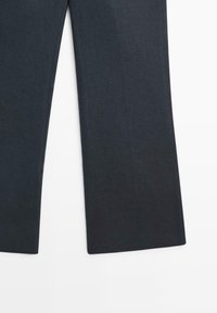 Dunkelgraue gerade geschnittene Hose, flach ausgelegt, zeigt die untere Hälfte der Beine auf weißem Hintergrund.