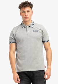 Lysegrå polo t-shirt lavet af bomuld, med en tre-knaps placket, marineblå stribede krave og ærmer, samt et logo på venstre bryst.