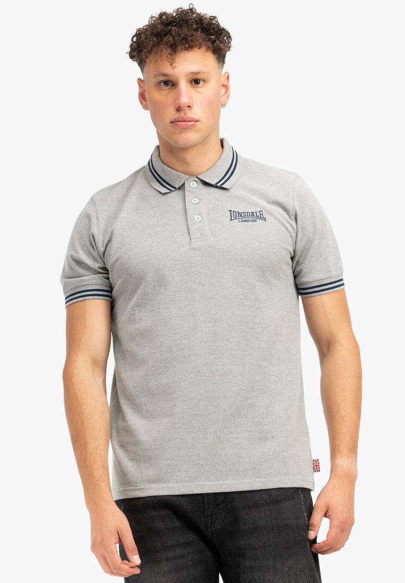 Lysegrå polo t-shirt lavet af bomuld, med en tre-knaps placket, marineblå stribede krave og ærmer, samt et logo på venstre bryst.