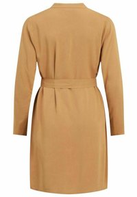 Robe beige à manches longues, avec col et ceinture à nouer à la taille. Tissu lisse avec une finition mate. Design simple et droit.