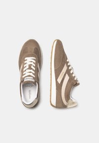 Baskets en daim marron avec rayures blanches et crème, bout rond, design à lacets, et accent doré sur la coque d'orteil. Semelle intérieure en mousse à mémoire de forme.