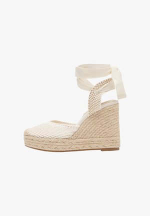 Espadrille compensée beige avec plateforme en jute tissé, dessus en mesh fermé et liens de cheville en ruban.