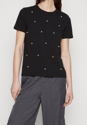 Sort kortærmet t-shirt med rund hals, der har et mønster af hvide perle-lignende udsmykninger jævnt fordelt foran.