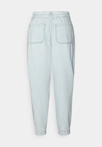 Jasnoniebieskie dżinsowe spodnie o luźnym kroju. Posiadają dwie tylne kieszenie, subtelnie sprany wzór oraz wywinięte mankiety. Brak widocznych elementów metalowych.