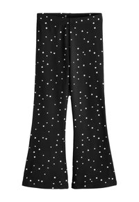 Mustad laiuvad püksid venivast kangast, millel on laiali laotatud valgete tähtmustritega.