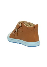Scarpa alta in pelle marrone con due cinturini in Velcro, punta bianca e suola azzurro chiaro, caratterizzata da cuciture senza soluzione di continuità lungo i bordi.