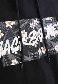 Mustikas hoodie, millel on valge ja oranž lilleline graafika, stiilse tekstiga üleval ning stringidega. Kangas tundub pehme ja tekstuurne.
