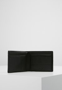 Portafoglio in pelle nera con slot multipli per schede e una finestra trasparente per l'ID, caratterizzato da un interno testurizzato e logo impresso. Design pieghevole per una facile conservazione.