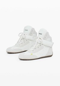 Vysoké tenisky v bílé semišové kůži s vyztuženými špičkami, plochými tkaničkami a suchým zipem; obsahují logo na jazyku a vzorované boční akcenty.