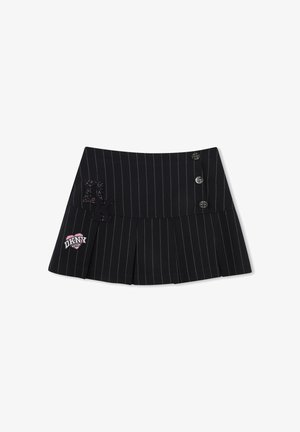 Mini-jupe plissée noire à fines rayures avec trois boutons décoratifs et patches, incluant un cœur rose et blanc avec le logo DKNY.