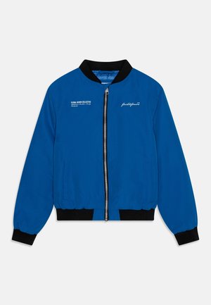 Niebieska kurtka typu bomber z czarnym prążkowanym kołnierzem i mankietami, wyposażona w srebrny zamek błyskawiczny, dwie boczne kieszenie oraz biały nadruk tekstowy na piersi.
