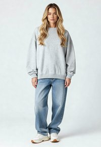 Harmaa huppari rennolla mitalla ja resoreilla, yhdistettynä vaaleisiin sinisiin väljiin farkkuihin ja valkoisiin tennareihin, joissa on kumipohja.