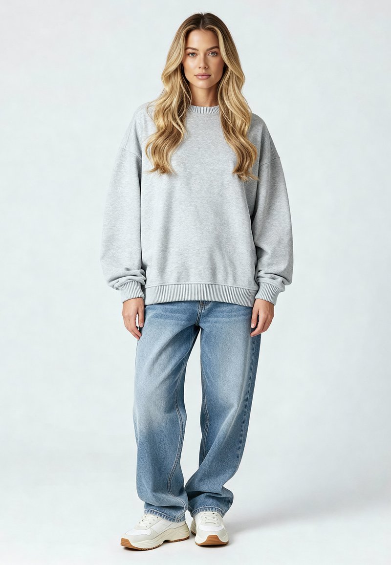 Harmaa huppari rennolla mitalla ja resoreilla, yhdistettynä vaaleisiin sinisiin väljiin farkkuihin ja valkoisiin tennareihin, joissa on kumipohja.