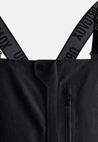 Schwarze wasserdichte Latzhose mit verstellbaren Trägern, ausgestattet mit einer Front-Reißverschlusstasche und Druckknopfverschluss. Glatte Textur, minimalistisches Design.