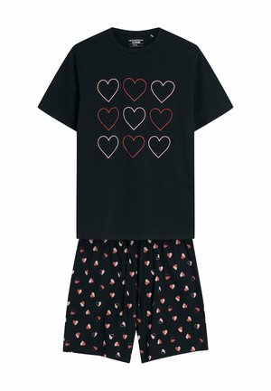 Czarny zestaw piżamy składający się z topu z krótkim rękawem, ozdobionego dziewięcioma konturowymi sercami w kolorze czerwonym i różowym, zestawiony z wzorzystymi szortami, które posiadają małe motywy serc.
