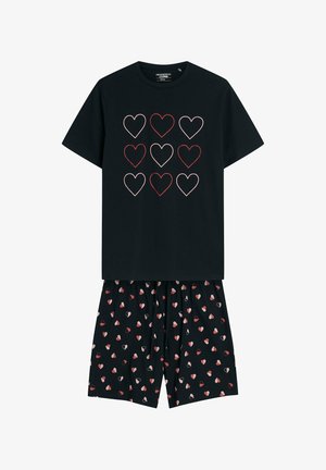 Czarny zestaw piżamy składający się z topu z krótkim rękawem, ozdobionego dziewięcioma konturowymi sercami w kolorze czerwonym i różowym, zestawiony z wzorzystymi szortami, które posiadają małe motywy serc.