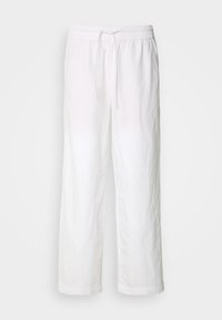 Pantalon blanc ample avec taille élastique et cordon, jambes droites et ourlets retroussés, présenté sur un fond clair uni.