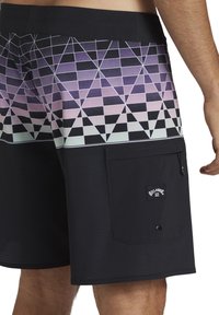 Svart simbyxor med ett geometriskt mönster i lila och gröna nyanser. Inkluderar en sidofick med lock. Tillverkade av lätt material.