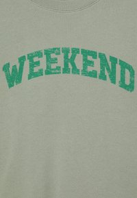 Lichtgroene sweatshirt met een ronde halslijn en gedurfde, getextureerde groene tekst "WEEKEND" over de borst. Gladde stofafwerking.