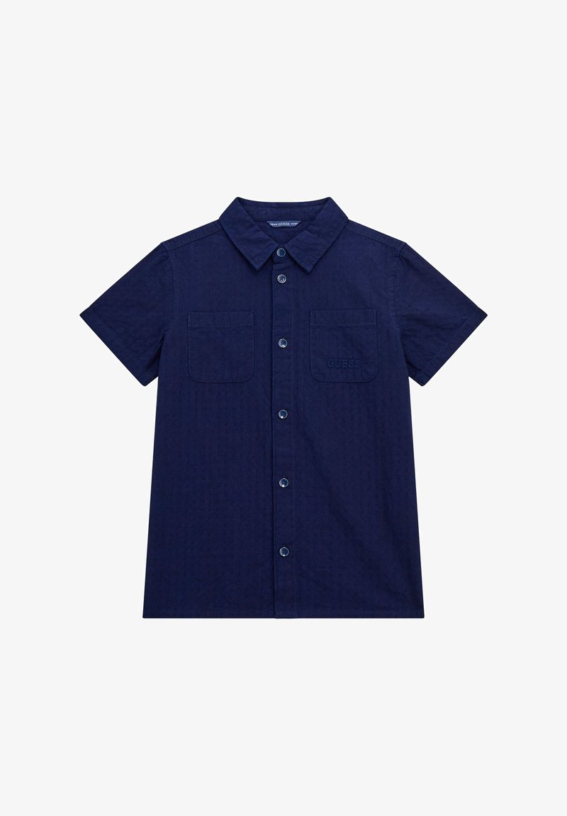 Cămașă albastră cu mânecă scurtă, cu nasturi, fabricată dintr-un material texturat. Dispune de două buzunare frontale și un logo brodat pe buzunarul stâng.