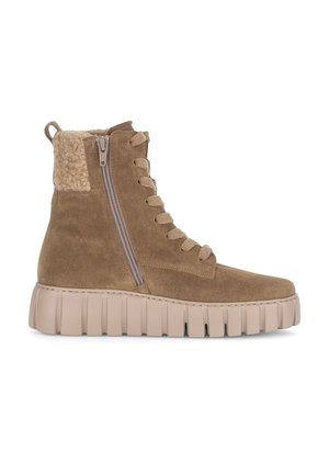 Bottes en daim marron jusqu'à la cheville avec un col en laine beige texturé, une fermeture éclair sur le côté et une semelle en caoutchouc beige épaisse avec un motif strié.