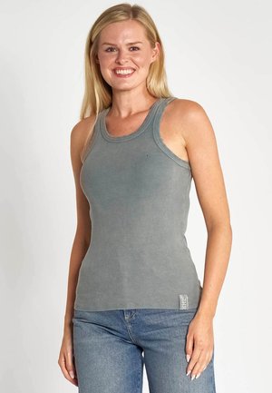 Graues, geripptes Tanktop mit rundem Ausschnitt und breiten Schulterträgern. Kombiniert mit blauen Jeans, versehen mit einem kleinen Markenzeichen am Saum.
